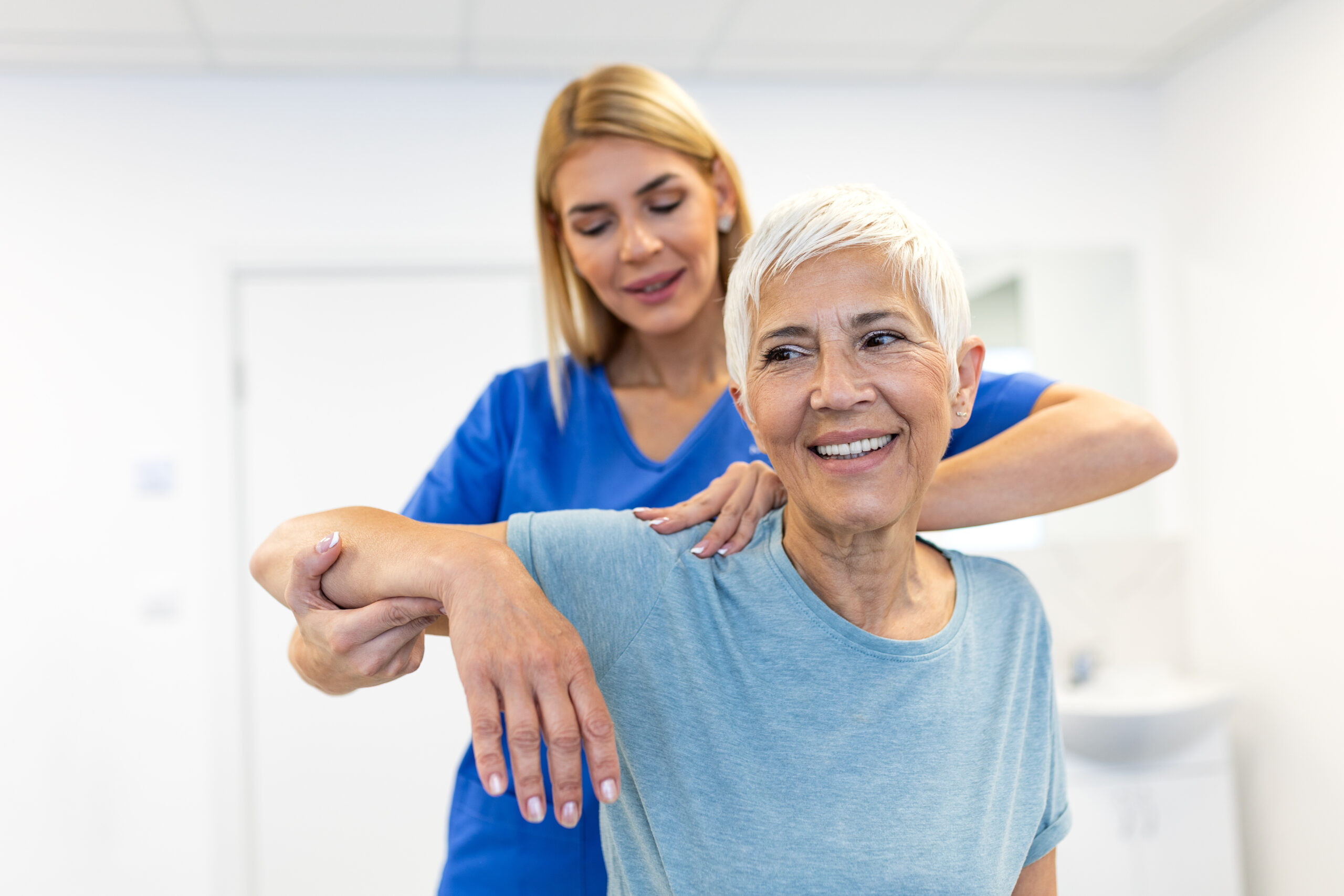 physical therapist examining her patient's shoulder during a pt appointment